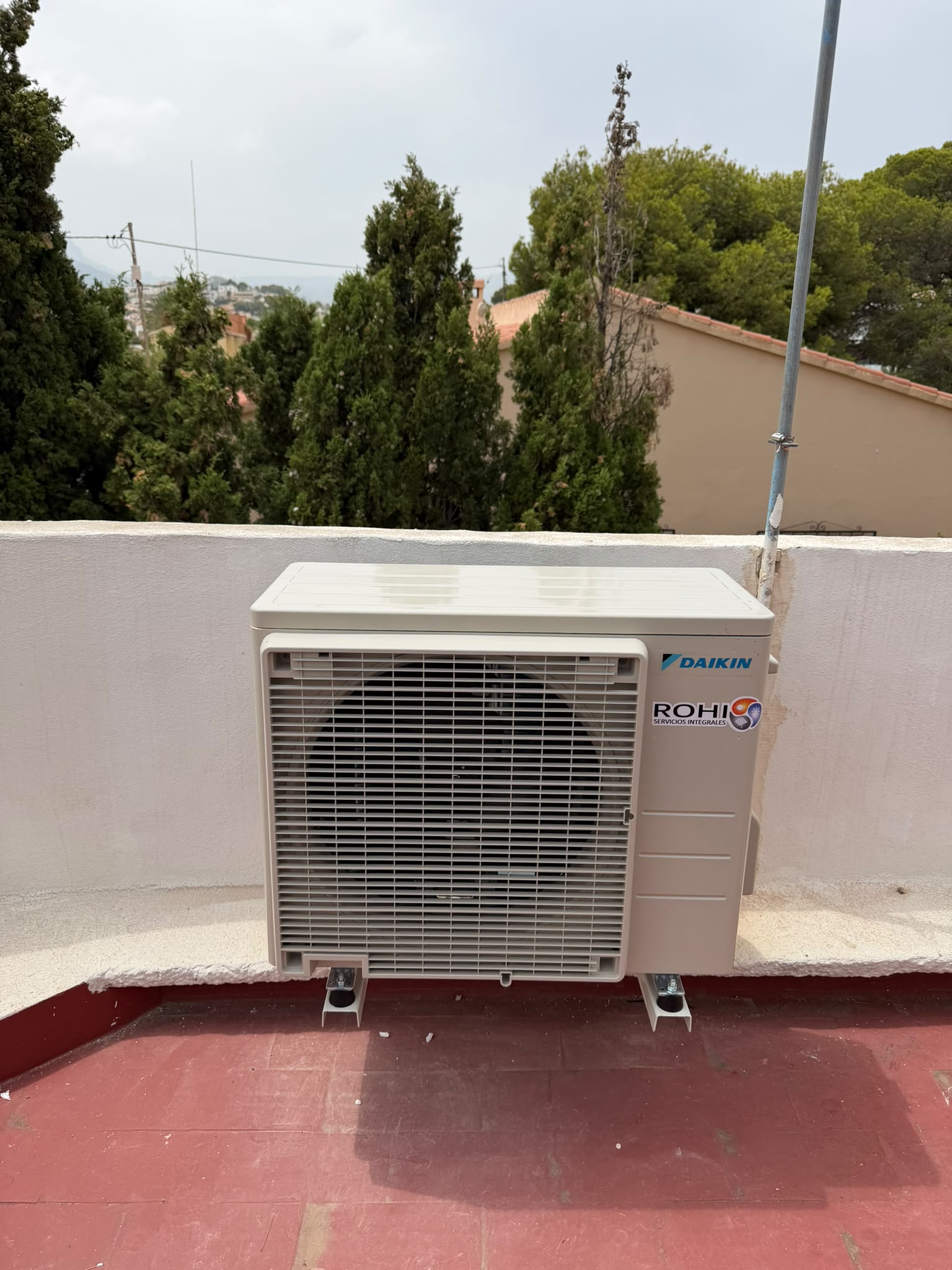 Daikin outdoor unit with ROHI sticker on a rooftop